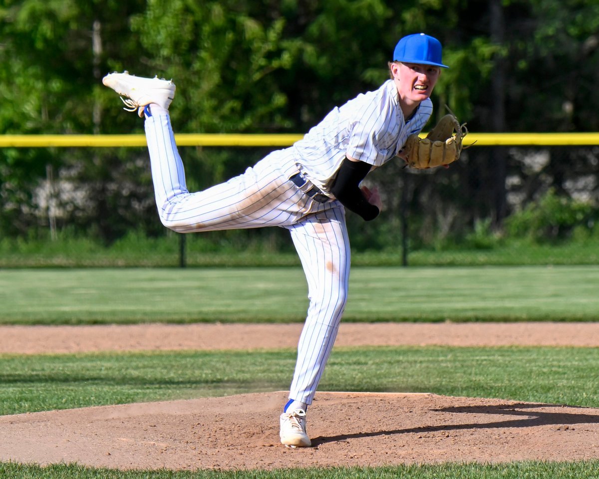 A high school baseball player after the pitch has left his hand and he follows thru